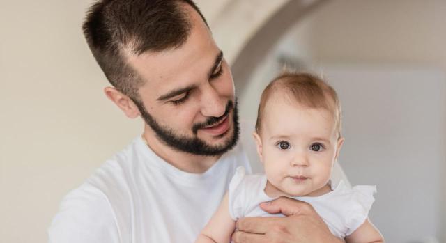 Prestación por nacimiento y cuidado de menor. Progenitor varón que no solicita las 6 semanas obligatorias posteriores al parto por encontrarse en IT. Imagen de un padre mirando a su bebe en brazos