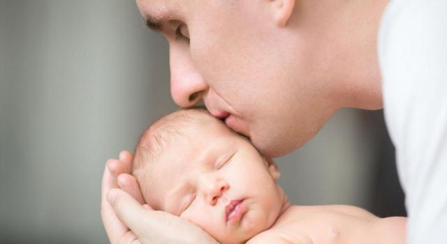 Padre besando a su hijo recién nacido