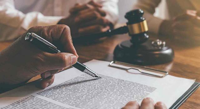 Prestación por cese de actividad; mutua colaboradora con la Seguridad Social; recurso de suplicación; consignación de la prestación. Notario revisa documento señalando con una pluma delante de una pareja