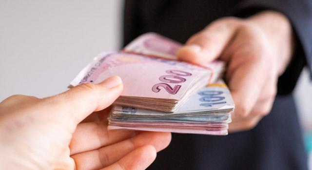 La trabajadora está obligada a restituir lo percibido. Imagen de dos manos sujetando un fajo de dinero