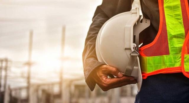 El RD 770/2025 entra en vigor el 4 de septiembre de 2025 Cambios en la normativa de seguridad industrial: flexibilidad en la contratación de personal. Imagen de la figura de un hombre con un casco blanco de obrero en su mano