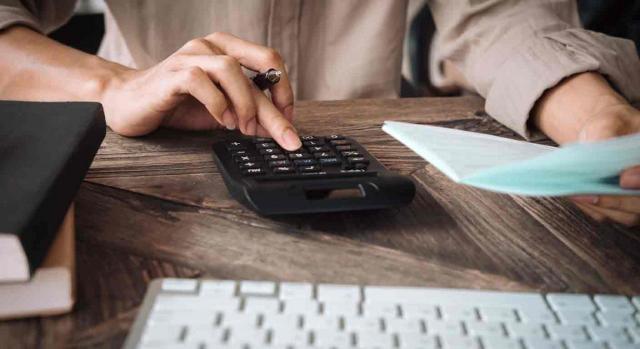 Alta dirección; desistimiento; preaviso; despido improcedente; indemnización; compensación. Mujer haciendo operaciones con una calculadora