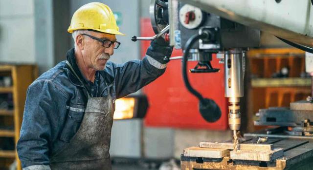 Operario usando una máquina en una fábrica