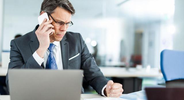 El incumplimiento empresarial convierte en salario ordinario lo pagado mensualmente. Imagen de un señor hablando por teléfono con el ordenador delante