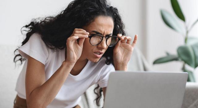 La Abogada General del TJUE entiende que la empresa debe proporcionar al trabajador gafas graduadas o su reembolso si utiliza pantallas de visualización. Imagen de una mujer joven mirando muy de cerca con gafas la pantalla del ordenador