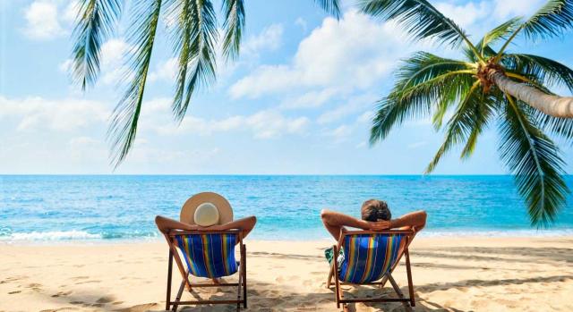 Convenio colectivo que establece, sin mayor precisión, que una parte de las vacaciones debe disfrutarse en periodo estival. Imagen de una pareja relajandose en unas tumbonas mirando al mar