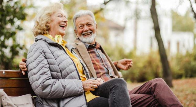 Las Cortes Generales aprueban la ley que garantiza el poder adquisitivo de las pensiones. Imagen de feliz pareja de ancianos sentados en el banco en el parque