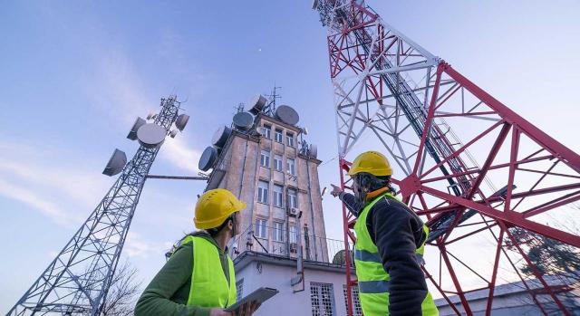 Periodo de guardia; disponibilidad no presencial; tiempo de trabajo. Imagen de ingenieros trabajando cerca de una torre de telecomunicaciones