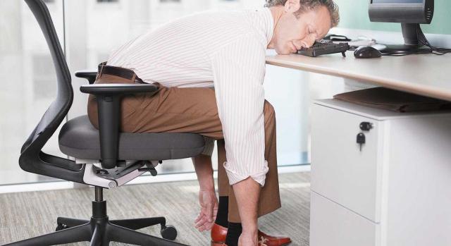 Periodo mínimo de descanso diario; jornada máxima; tiempo de trabajo. Imagen de una empresario durmiendo encima de un teclado de ordenador