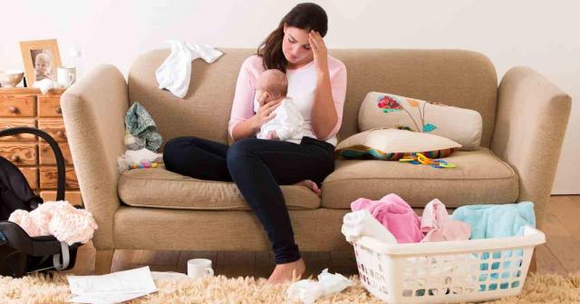 Permisos adicionales de maternidad para proteger la condición biológica de las madres que cuidan de sus hijos ellas solas. Imagen de una madre con su bebé en el sofá de su casa