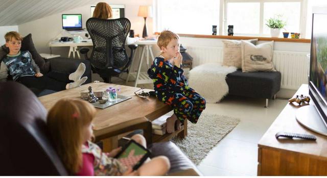 Permiso obligatorio, retribuido y recuperable. Imagen de una señora teletrabajando con sus hijos en el salón 