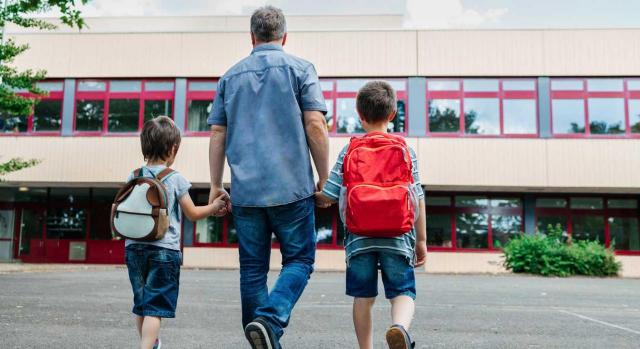 La decisión denegatoria injustificada es nula. Imagen de padre llevando a sus hijos al colegio