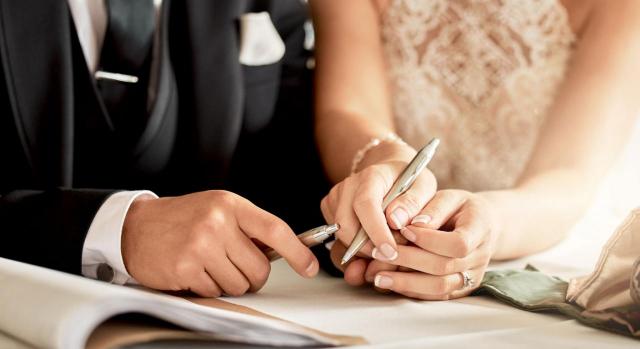 Permisos; hecho causante; cómputo. Imagen de un matrimonio firmando el certificado de boda