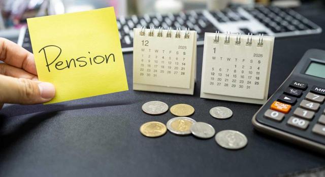 Publicado el real decreto de revalorización de pensiones 2026 Publicado el real decreto de revalorización de pensiones 2026. Imagen de un post-it con la palabra pensión y calendarios y calculadora en la mesa