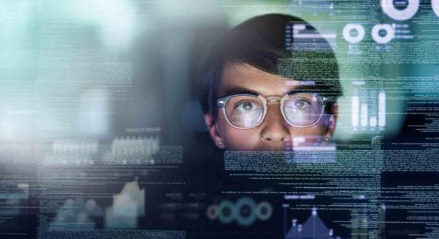 despido disciplinario; derecho a la intimidad; secreto de las comunicaciones; monitorización del ordenador. Programadora mirando atentamente el ordenador y reflejado en su cara códigos informáticos