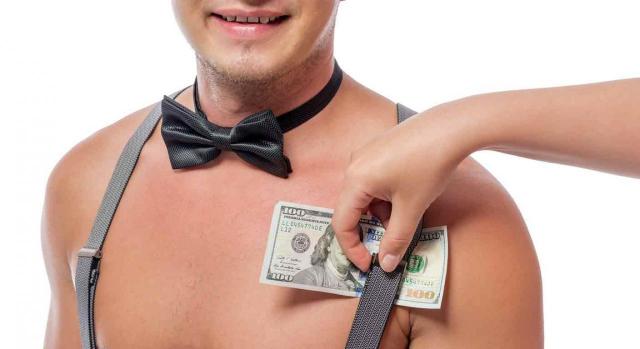 Prostitución voluntaria por cuenta ajena. Mano femenina pone dólares debajo del tirante de un hombre desnudo