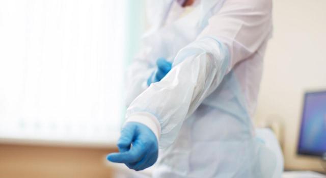 Medios de protección al personal sanitario Medios de protección al personal sanitario. Sanitario poniéndose traje de protección