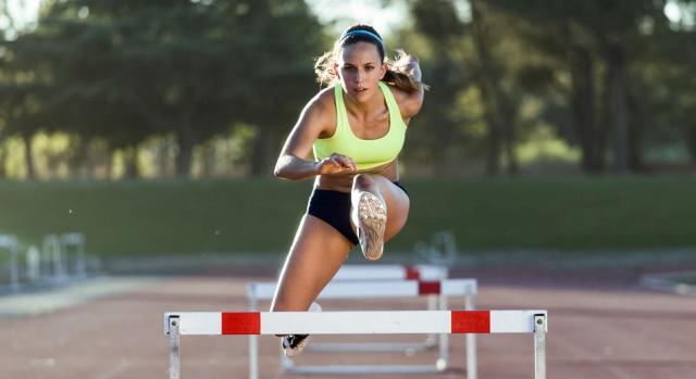 Protocolo básico de entrenamiento. Jóven atleta saltando un obstáculo