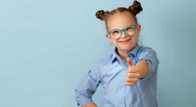 Reforma del artículo 49 de la Constitución Española. Imagen de una niña con sindrome de dawn muy sonriente en un estudio de fotografía