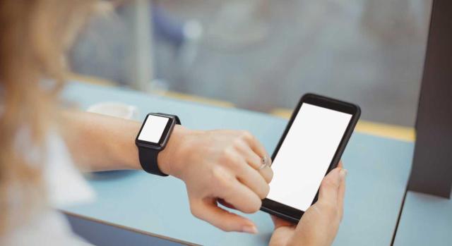 El nuevo registro horario digital: más control y nuevas obligaciones para las empresas. Imagen de una chica mirando su reloj para poder fichar en su movil