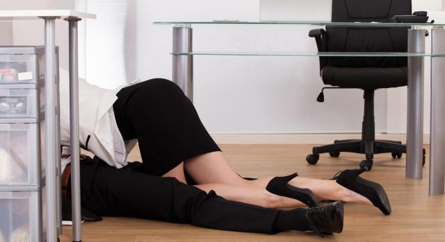 ¿«Hacer el amor» en el trabajo perjudica seriamente la continuidad de la relación de empleo? Imagen de dos adultos tirados en el suelo debajo del escritorio de la oficina