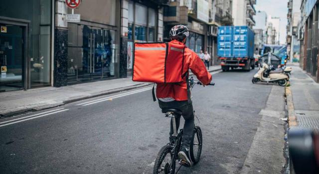 los repartidores de Deliveroo son trabajadores por cuenta ajena según el TSJ Aragon. Imagen de repartidor en bicicleta por la ciudad