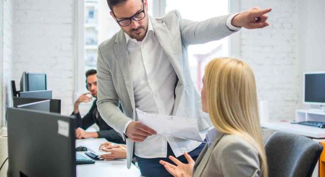 despido de trabajadores en IT; nulidad; discapacidad; enfermedad. Responsable oficina señala hacia afuera con la mano a una empleada que se está sombrada