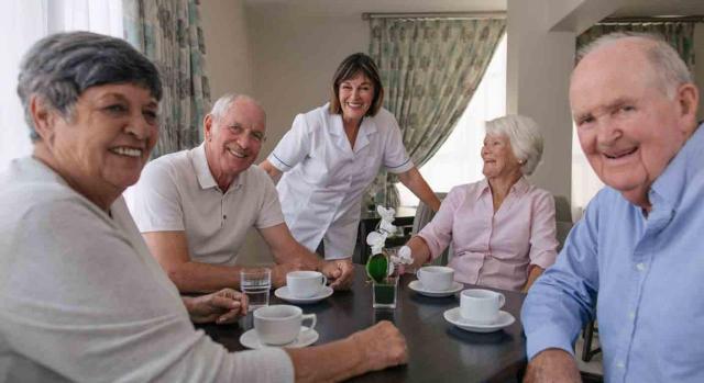 Interinidad por vacante; permuta de puesto de trabajo. Cuatro mayores tomando café en una residencia