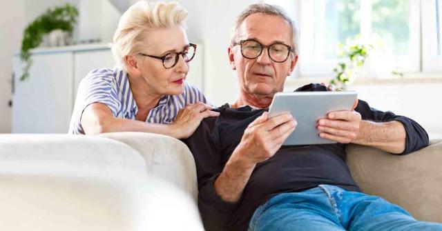 Publicado el real decreto de revalorización de pensiones. Imagen de una pareja de pensionistas mirando una tablet