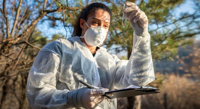 Riesgos laborales: protección frente a agentes biológicos. Imagen de una bióloga cogiendo muestras