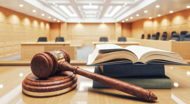 El despido debe calificarse como nulo. Primer plano de mesa con elementos de carácter judicial y sala al fondo