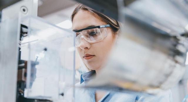 La mujer en la Seguridad Social. Mujer con gafas protectoras en su puesto de trabajo