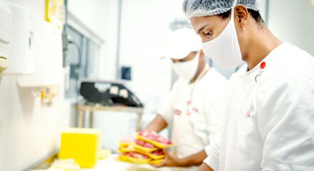 Socios de cooperativa de trabajo asociado que prestan servicios en otra empresa mediante subcontratación. Imagen de carnicero trabajando en una tienda
