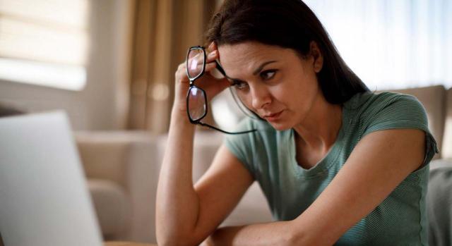 El art. 41 del ET no permite de forma indiscriminada que el empleador modifique condiciones colectivas. Imagen de mujer sentada frente al ordenador pensativa