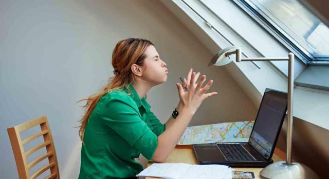 Desconexiones que impidan la prestación del teletrabajo. Mujer delante del portátil con gesto de enfado