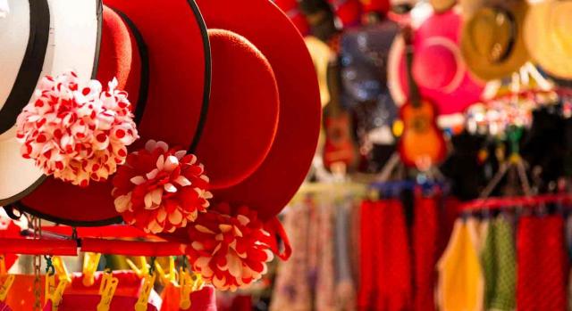 Artículos de souvenir, sombreros, flores y vestidos en una tienda de Sevilla