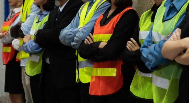 TS. No vulnera el derecho a la libertad sindical la limitación convencional de la acumulación del crédito horario ceñida a aquellos sindicatos que acrediten una implantación mínima a nivel estatal del 10% en el sector. Imagen de unos trabajadores de brazos cruzados con su chaleco reflectante