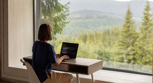 Competencia territorial de los órganos del Orden Social cuando se está en teletrabajo. Imagen de una mujer teletrabajando mirando hacia la naturaleza